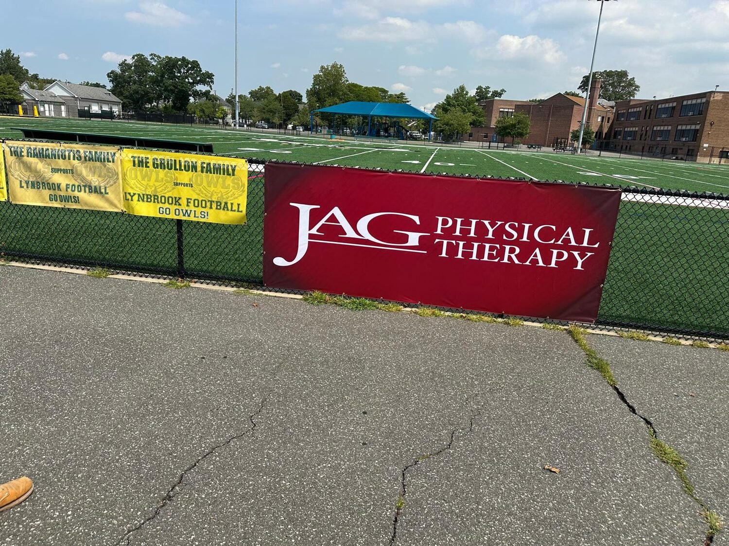 Sponsor banners on the field fence for Lynbrook Football