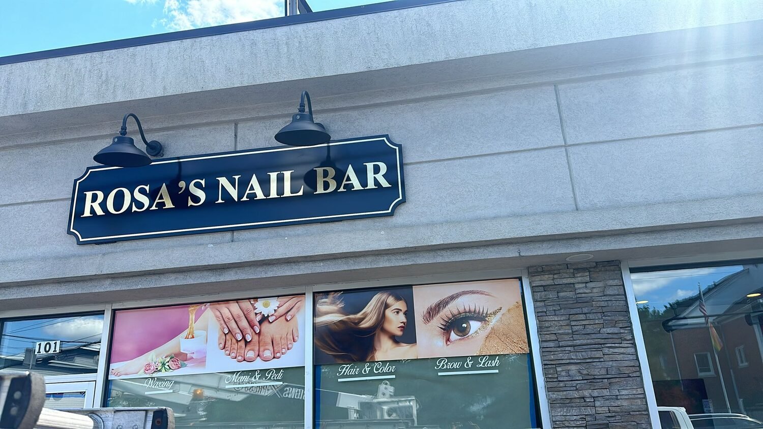 Carved sign with gooseneck lighting for Rosa's Nail Bar