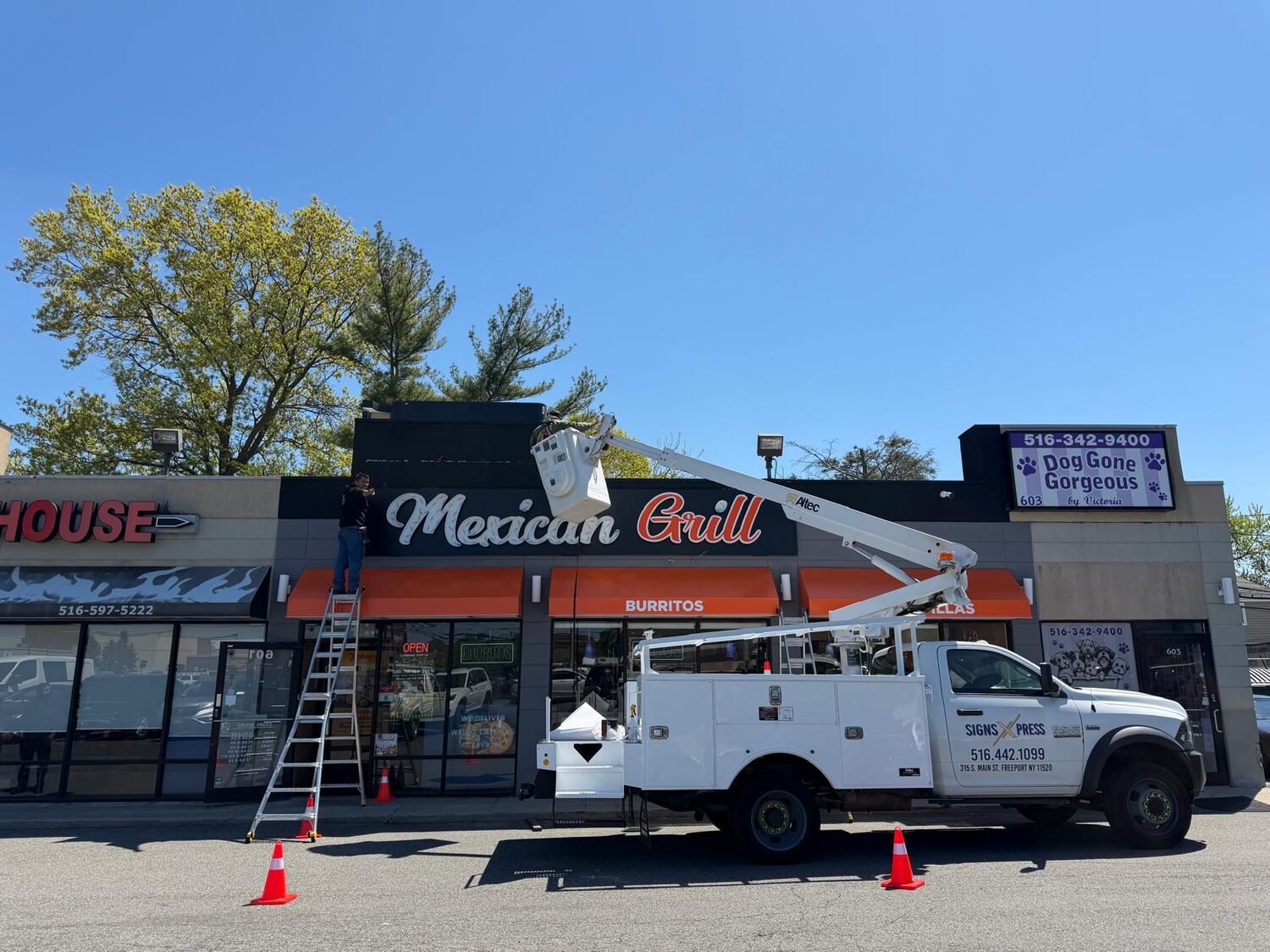 Crew installing channel letters from a bucket truck