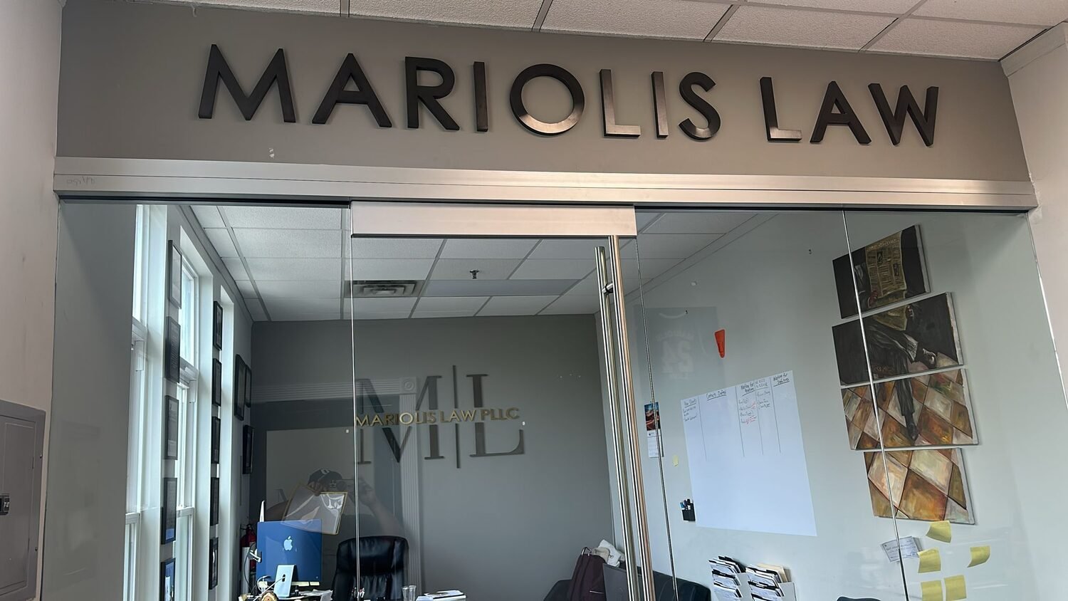 Dimensional letters over a glass entry for Mariolis Law PLLC